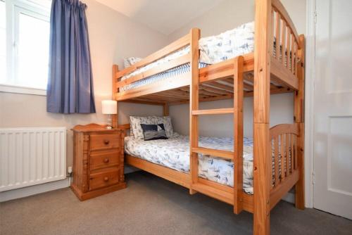 a bedroom with two bunk beds and a desk at Inveray in Seahouses