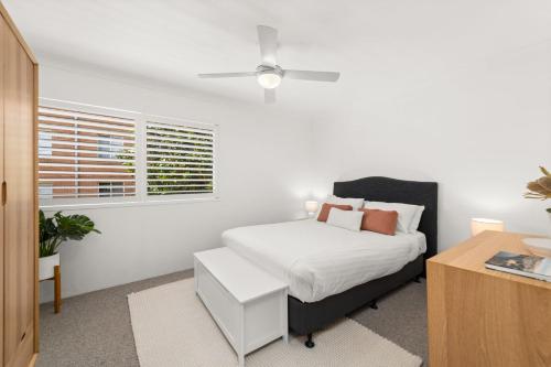 a white bedroom with a bed and a desk at South Pacific Unit 5 13 Shoal Bay Road in Shoal Bay
