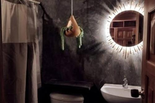 a bathroom with a mirror and a toilet and a sink at Naturaleza, Descanso y Fogata, Casa de Campo Romeros in Iza