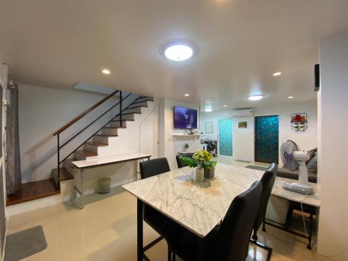 a living room with a table and a staircase at NB Bangsaen House in Ban Puk (2)