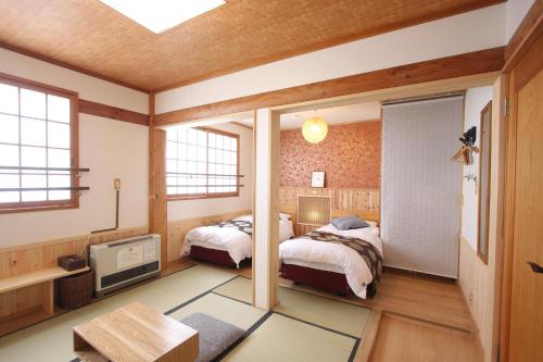 een slaapkamer met 2 bedden en een tv. bij Koguma no ie in Nozawa Onsen