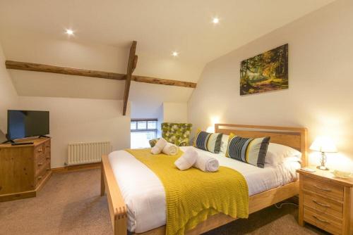 a bedroom with a large bed with a yellow blanket at East Havers in Alnwick