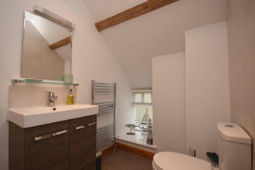 a bathroom with a sink and a toilet and a window at East Havers in Alnwick