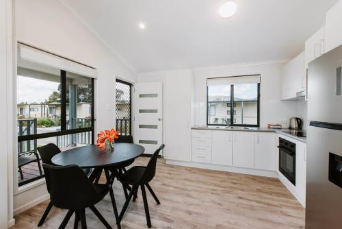 a kitchen and dining room with a table and chairs at Mudgee Valley Park in Mudgee