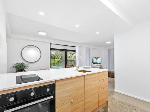 una cocina con fregadero y estufa en 11 Attunga Heights Noosa Heads, en Noosa Heads
