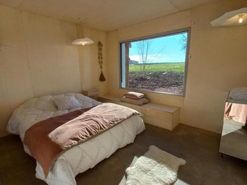 een slaapkamer met een bed en een groot raam bij Gîte Saint-Forgeux-Lespinasse, 6 pièces, 12 personnes - FR-1-496-7 in Saint-Forgeux-Lespinasse