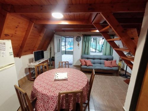 uma sala de jantar com uma mesa e um sofá em Alpina La Luna em Valle Hermoso
