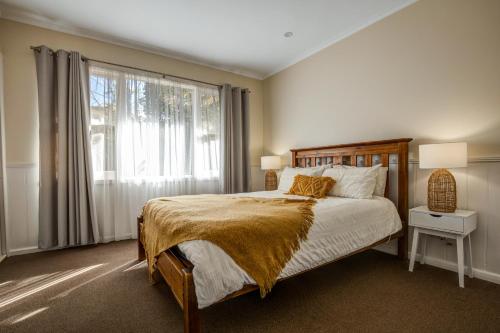 a bedroom with a bed and a large window at Viewhill Holiday Units - Bright in Bright