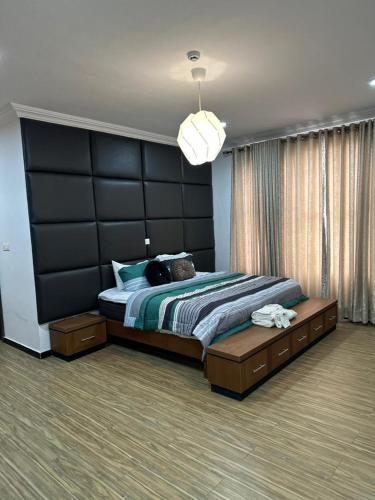 a bedroom with a large bed with a black headboard at Nigus House Oniru in Lagos