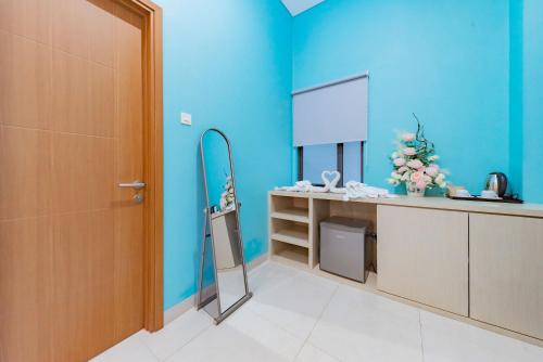 a bathroom with a mirror and a blue wall at Sans Hotel Alexander Bandung in Bandung