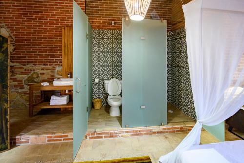 a bathroom with a toilet and a brick wall at Ex Hacienda San José in Oaxaca City