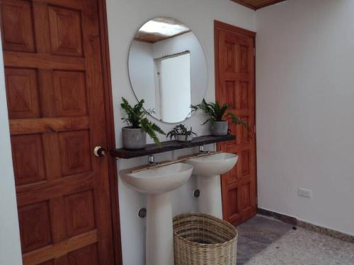 baño con lavabo, espejo y puerta en Fogata Naturaleza y Descanso, Casa de Campo Eucaliptos, en Iza