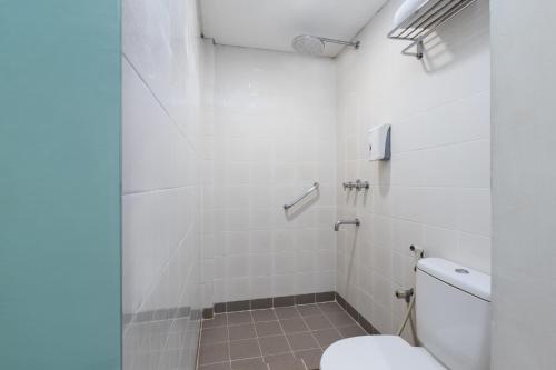 a white bathroom with a toilet and a shower at Amaris Hotel Padjajaran - Bogor in Bogor