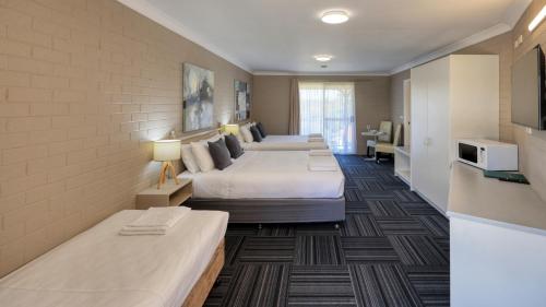 um quarto de hotel com duas camas e uma cozinha em Canowindra Riverview Motel em Canowindra