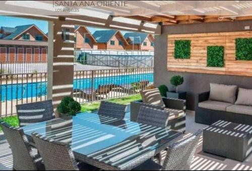 une terrasse avec une table, des chaises et une piscine dans l'établissement Extraordinario depto ejecutivo, à Los Ángeles
