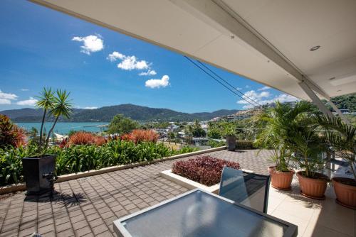 un patio con vistas al agua y a las montañas en Waterview Airlie Beach, en Airlie Beach