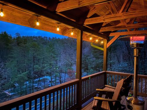 a porch with a view of the woods at night at Toccoa River View in Blue Ridge