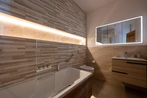 een badkamer met een groot bad en een wastafel bij Keildon in Seahouses