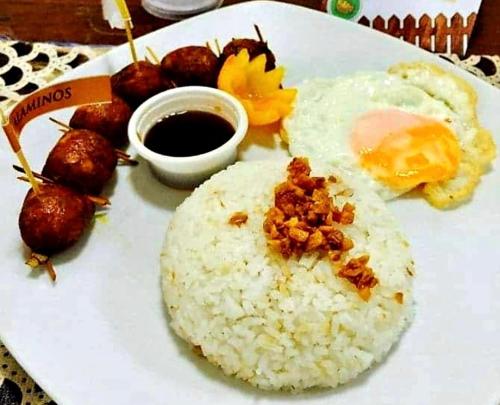 a white plate with rice and eggs and other foods at Alona's Traditional Filipino Home near 100 Islands Wharf in Alaminos