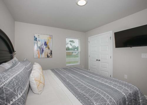 a bedroom with a bed and a flat screen tv at Grand Getaway House in Foley