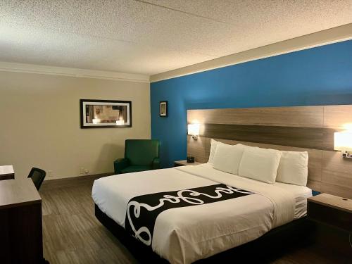 a hotel room with a large bed and a chair at La Quinta Inn by Wyndham El Paso East Lomaland in El Paso