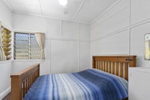 a white bedroom with a bed and a window at Relax on Rickman in Woorim