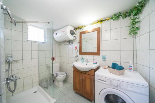 W łazience znajduje się pralka i umywalka. w obiekcie Key to Sunset w mieście Angón