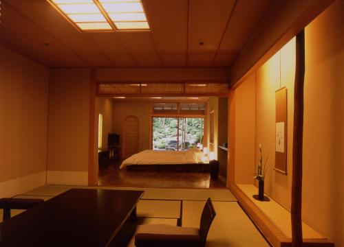 a bedroom with a bed and a large window at Gora Kadan in Hakone