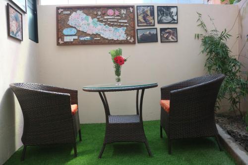 a table and two chairs with a vase on it at Hotel Family Ties Pvt. Ltd. in Kathmandu