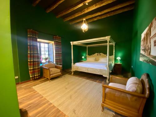 1 dormitorio con cama y pared verde en Casona Lo Aguirre en Talagante