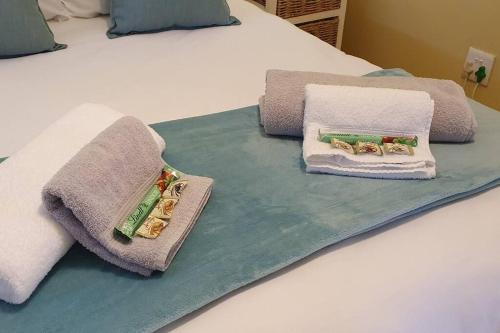 ein Bett mit Handtüchern darüber in der Unterkunft Jakaranda Cabin - Self Catering Apartment in Secunda