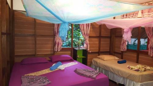 Baan Suan Kayoo 2 في كو فايام: سريرين في غرفة بها مظلة