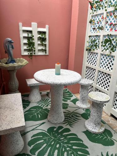 Pearls Place في Arima: طاولة عليها شمعة في الغرفة