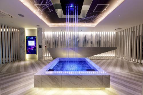 a lobby with a fountain in the middle of a room at Hotel Cocoon -Urban Luxury- 