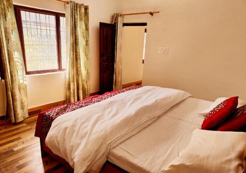 een slaapkamer met een bed in een kamer met een raam bij Kiran Lake Paradise Homestay in Bhīm Tāl