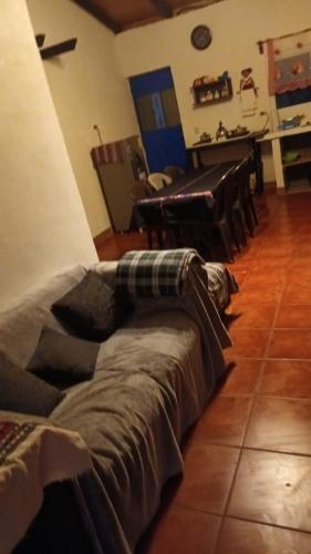 a living room with a couch and a piano at Hostal El Calvario del Bosque, Aldea Las Cruces, Cobán 