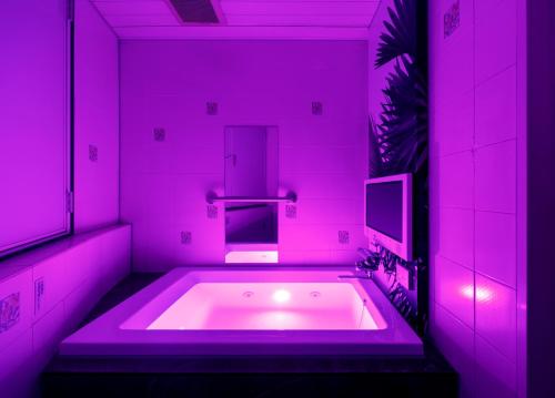 にあるHotel Cocoon -Urban Luxury-のピンクのバスルーム(シンク付きのバスタブ付)