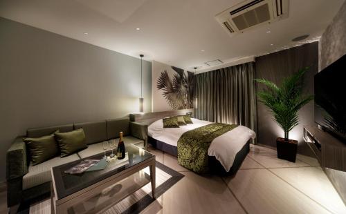 a hotel room with a bed and a couch at Hotel Cocoon -Urban Luxury- in Suka