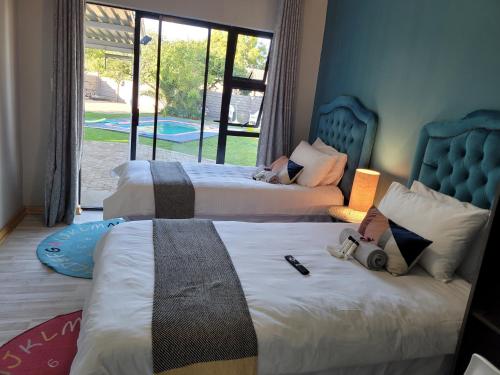 two beds in a bedroom with a view of a pool at Ayana bnb in Bloemfontein