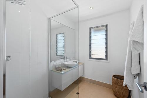 a white bathroom with a sink and a mirror at Relaxed Luxury In Paradise - A touch of Breeze! in Sunrise Beach