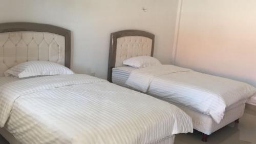 two beds sitting next to each other in a bedroom at Hotel My New Lovina in Lovina