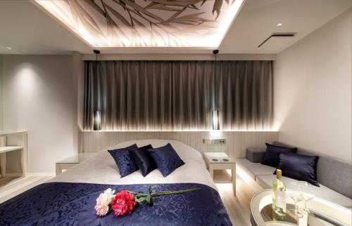 a bedroom with a bed with flowers on it at Hotel Cocoon -Urban Luxury- in Suka