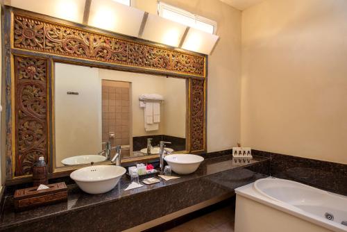 a bathroom with two sinks and a large mirror at Diamonds Dream of Africa in Malindi