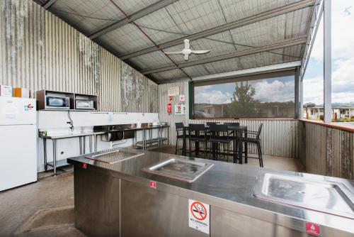 a kitchen with tables and chairs and a large window at Mudgee Valley Park in Mudgee