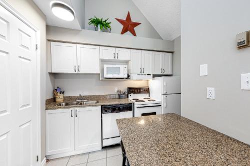 a kitchen with white cabinets and a star on the wall at Condo 916 at North Creek Resort in Blue Mountains