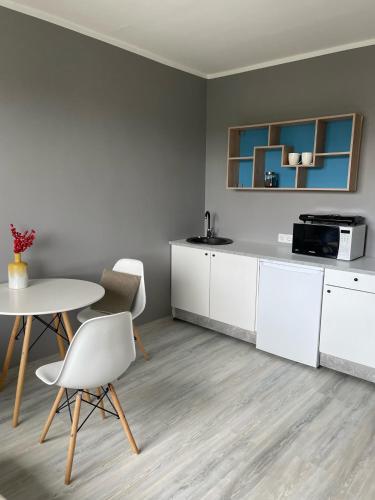 a kitchen with white cabinets and a table and chairs at Light grey apartment in Maardu in Maardu