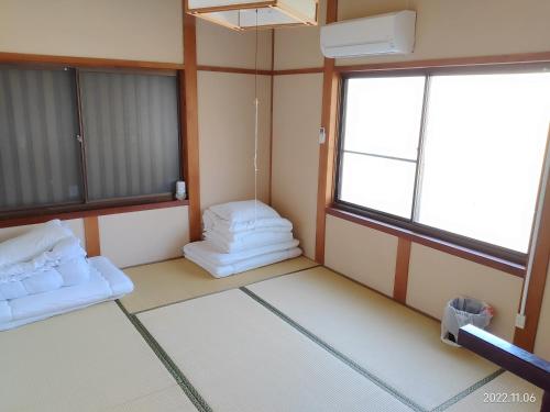 Suo Oshima的住宿－イマジンウエストオーシャン（ImagineWestOcean），带两张床和两个窗户的房间