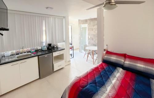 a bedroom with a colorful bed and a kitchen at Habitaciones Amubladas Logos II in Veracruz