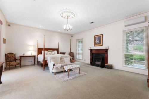 a large bedroom with a bed and a fireplace at Montfort Manor in Traralgon