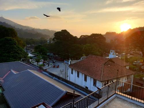 um par de pássaros voando no céu sobre uma cidade em Kandy Tower Inn em Kandy